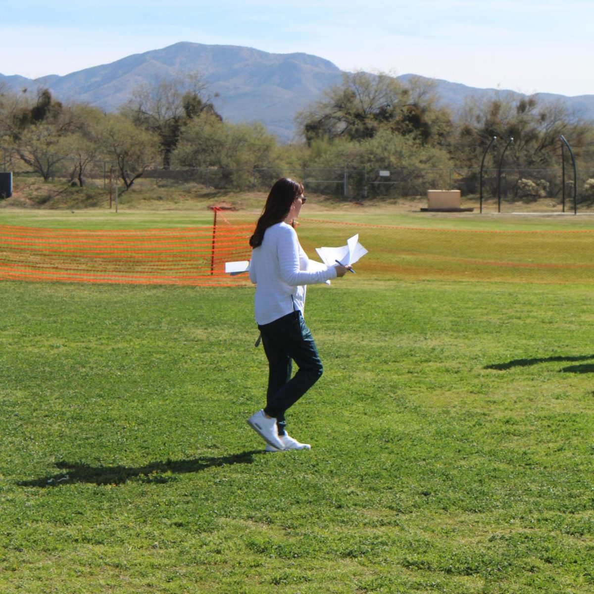 Ms. Batten on the field getting ready for class.